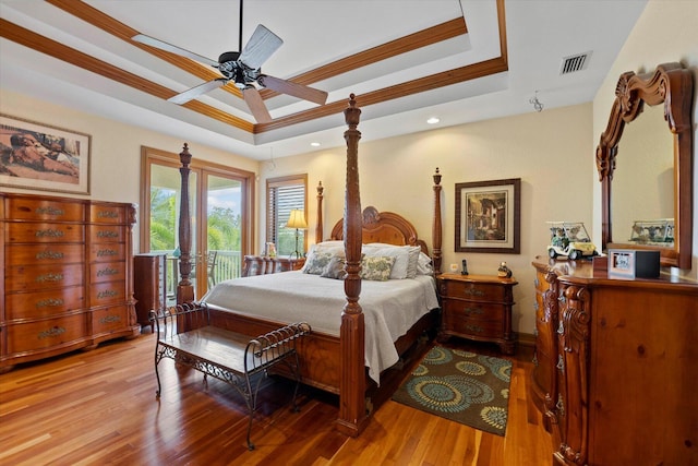 bedroom featuring access to exterior, a tray ceiling, ceiling fan, crown molding, and light hardwood / wood-style flooring