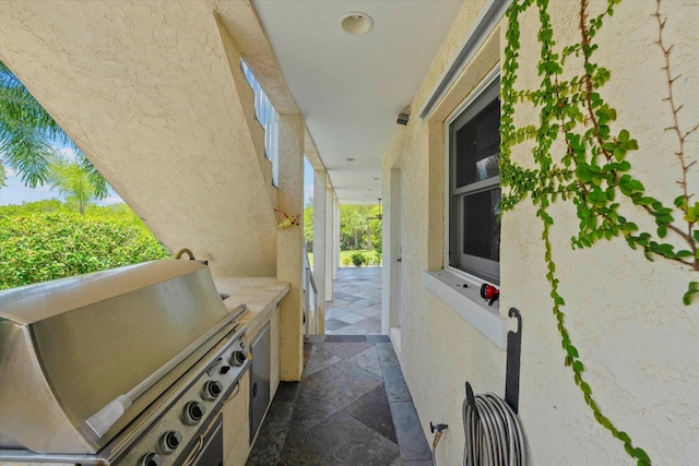 view of patio / terrace featuring exterior kitchen and a grill