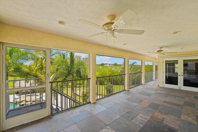 unfurnished sunroom featuring french doors and ceiling fan