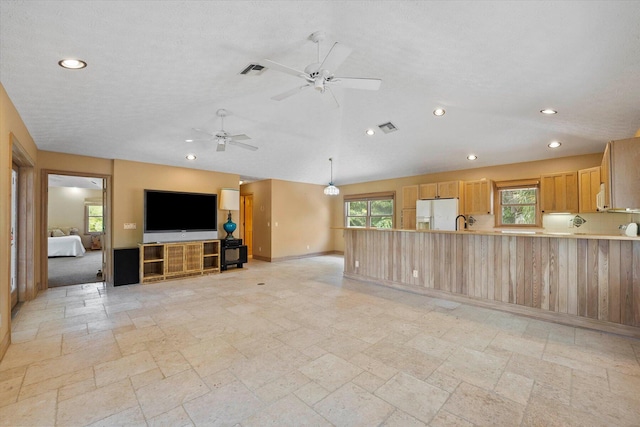 living room featuring ceiling fan, sink, and a textured ceiling