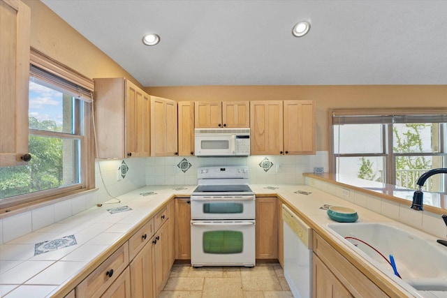 kitchen with sink, tile countertops, white appliances, decorative backsplash, and light brown cabinetry