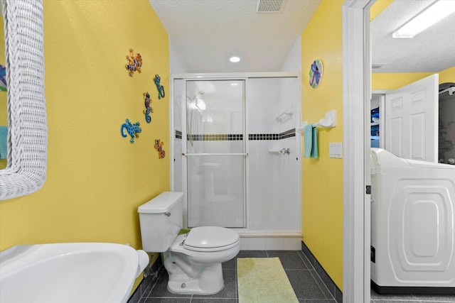 bathroom with toilet, tile patterned flooring, a shower with door, and washer / dryer