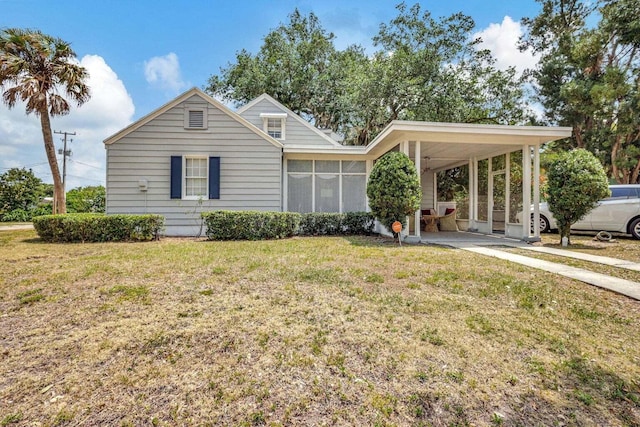 view of front of house with a front yard, a carport, and a sunroom