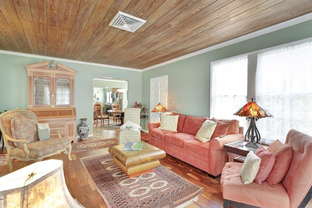 living area with crown molding, wood finished floors, arched walkways, wooden ceiling, and visible vents