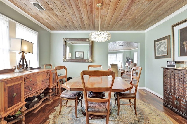 dining area with crown molding, wood finished floors, arched walkways, wooden ceiling, and visible vents