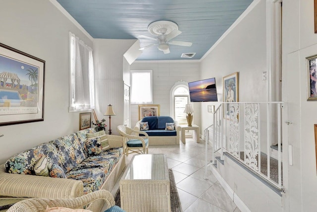 living room featuring ceiling fan, light tile patterned flooring, ornamental molding, and wood ceiling