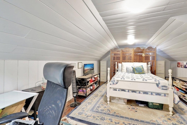 bedroom with hardwood / wood-style flooring, wood walls, and lofted ceiling