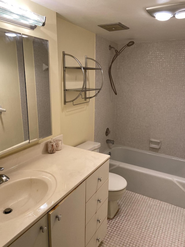 full bathroom featuring toilet, tile patterned floors, tiled shower / bath, and vanity