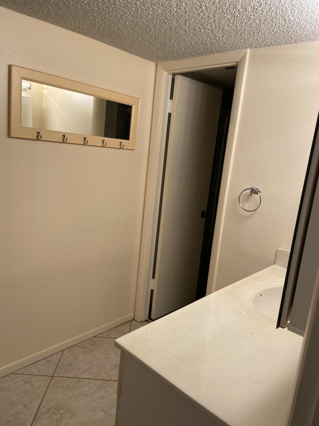 bathroom featuring tile patterned flooring, sink, and a textured ceiling