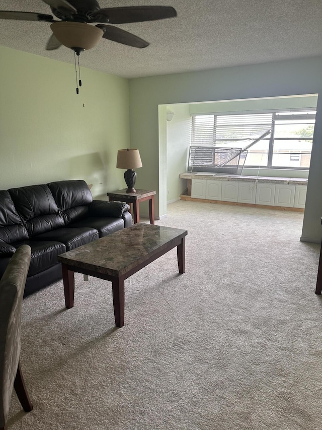 living room featuring light carpet, ceiling fan, and a textured ceiling