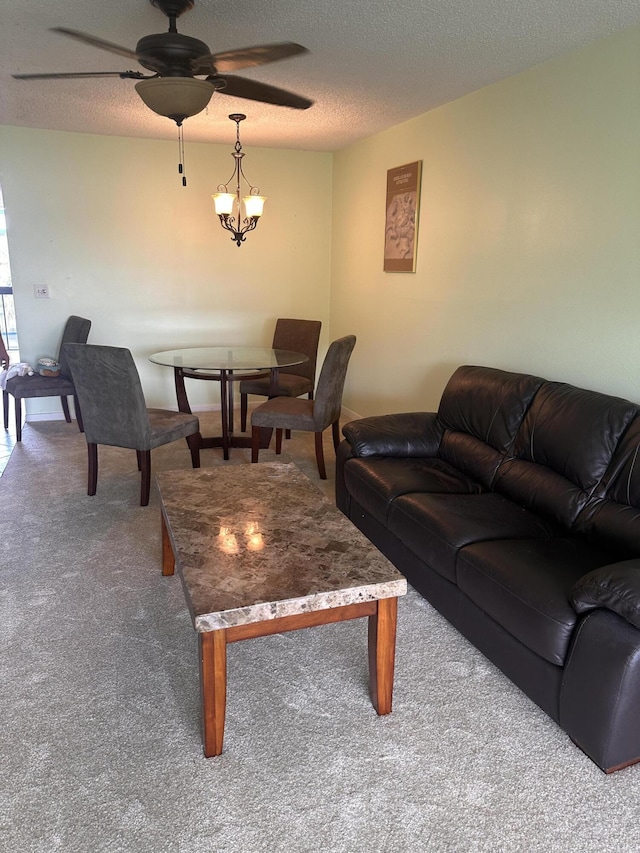 living room with ceiling fan with notable chandelier, a textured ceiling, and carpet flooring