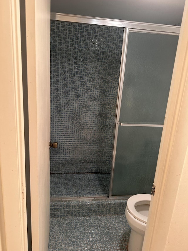 bathroom with toilet, tile patterned flooring, crown molding, and an enclosed shower