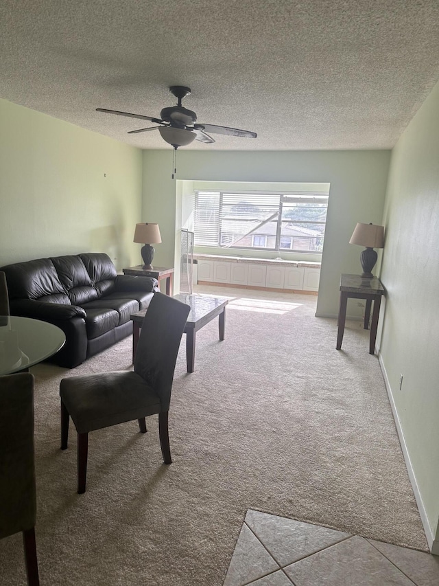 living room featuring ceiling fan, carpet, and a textured ceiling