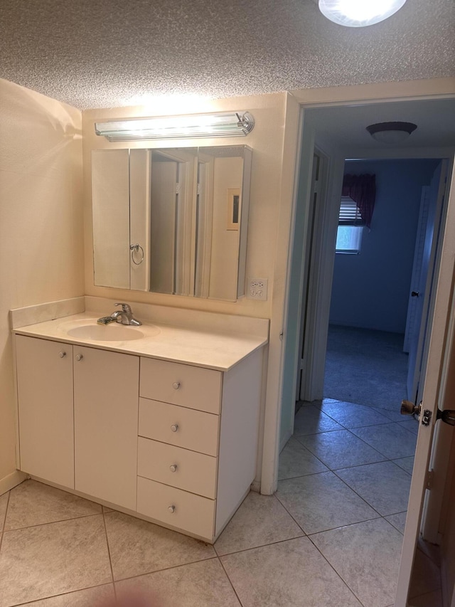 bathroom with a textured ceiling, tile patterned floors, and vanity