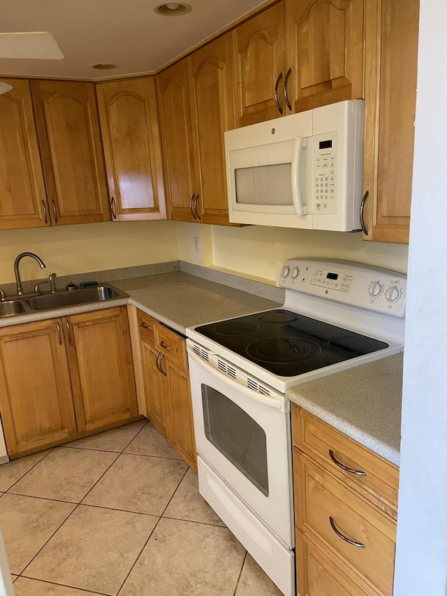 kitchen with sink, white appliances, and light tile patterned floors