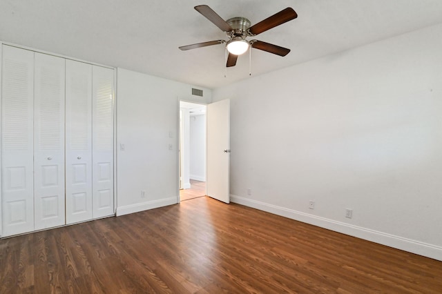 unfurnished bedroom with ceiling fan, dark hardwood / wood-style floors, and a closet