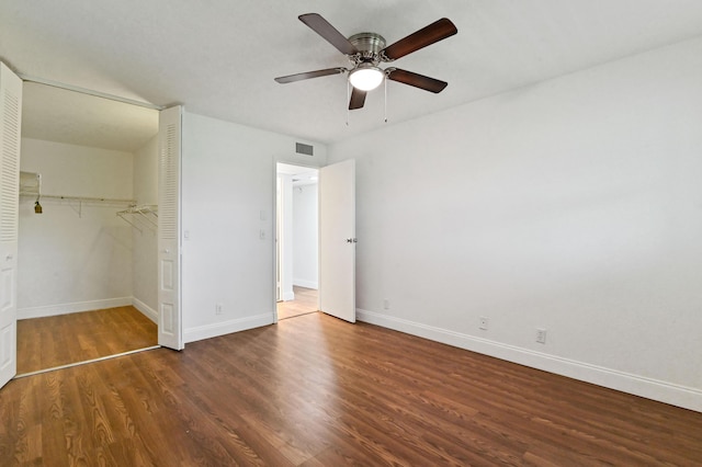 unfurnished bedroom with a closet, dark hardwood / wood-style floors, and ceiling fan