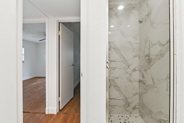 bathroom featuring a tile shower, ceiling fan, and hardwood / wood-style floors