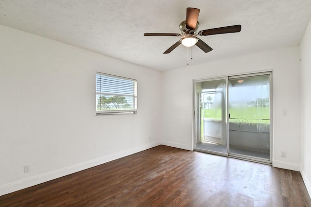 empty room with ceiling fan and dark hardwood / wood-style flooring