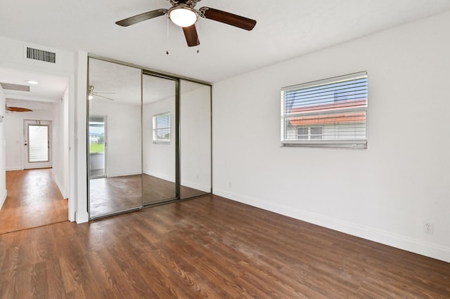 unfurnished bedroom featuring a closet, ceiling fan, and dark wood-type flooring