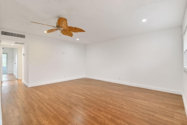 spare room with ceiling fan and light wood-type flooring