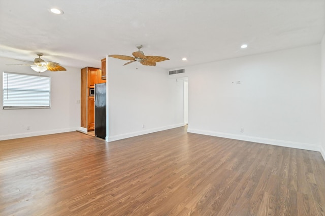 unfurnished living room featuring ceiling fan and wood-type flooring