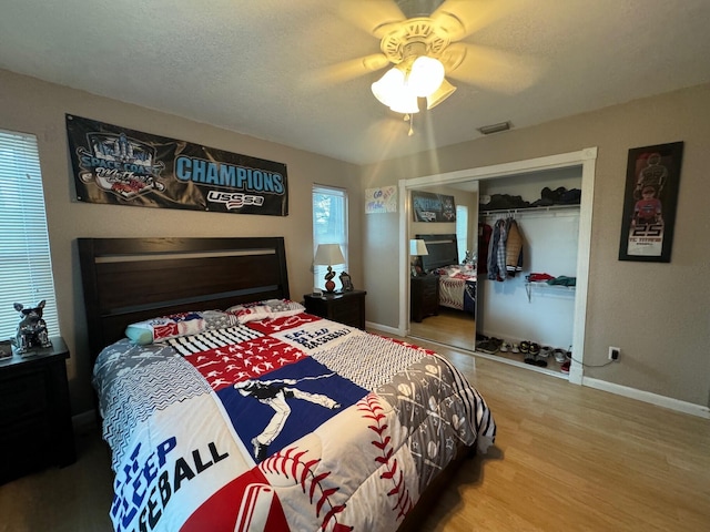 bedroom with ceiling fan, a closet, hardwood / wood-style flooring, and a textured ceiling