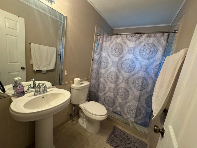 bathroom featuring tile flooring, ornamental molding, and toilet