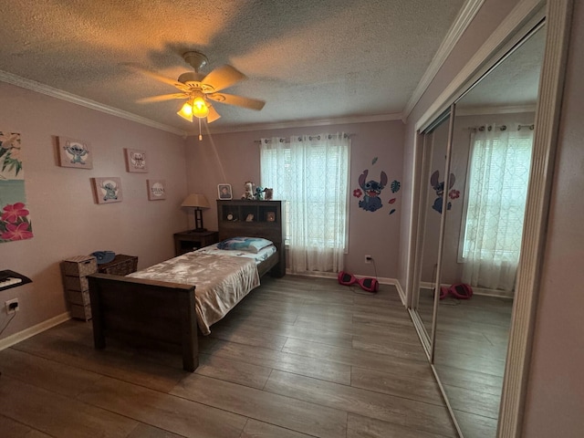 bedroom with ceiling fan, a closet, hardwood / wood-style flooring, and multiple windows