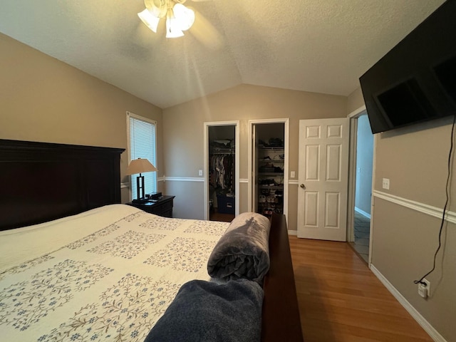 bedroom with vaulted ceiling, a closet, ceiling fan, hardwood / wood-style flooring, and a spacious closet