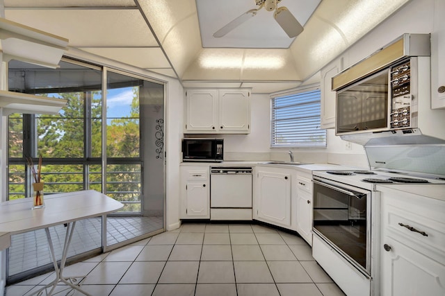 kitchen featuring white cabinets, light tile patterned flooring, white appliances, and sink