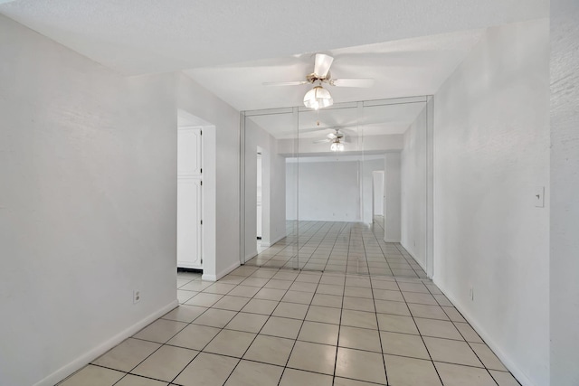 corridor featuring light tile patterned floors and a textured ceiling