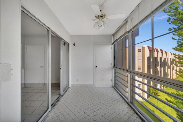 unfurnished sunroom with ceiling fan