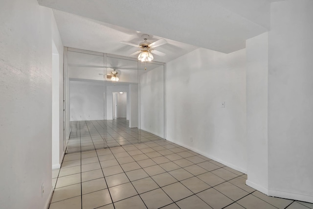 empty room featuring ceiling fan and light tile patterned flooring