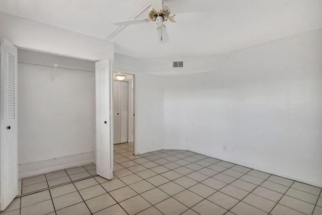 unfurnished bedroom featuring ceiling fan, light tile patterned floors, and a closet