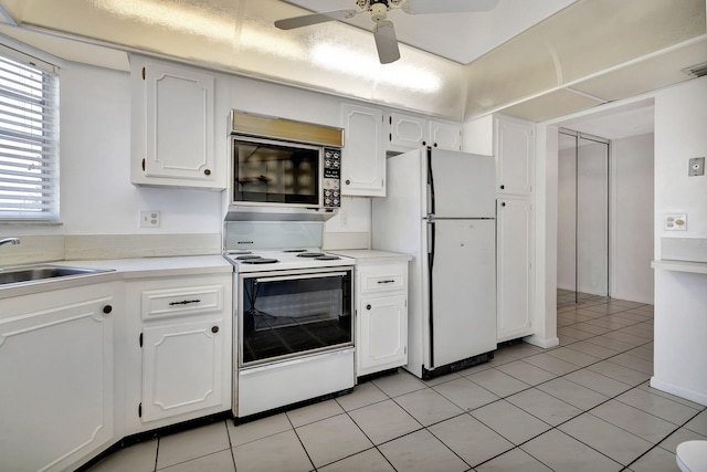 kitchen with sink, white cabinets, white appliances, and light tile patterned floors