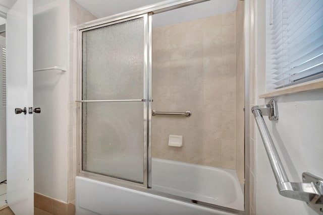 bathroom featuring bath / shower combo with glass door