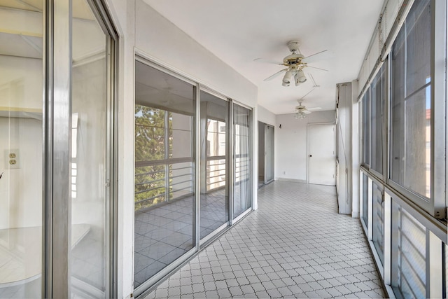 unfurnished sunroom with ceiling fan