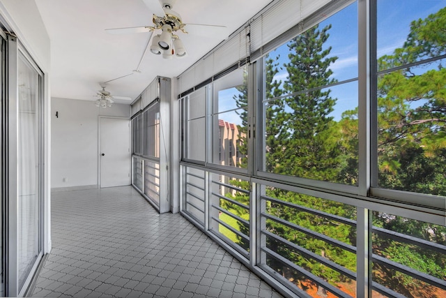 unfurnished sunroom with ceiling fan