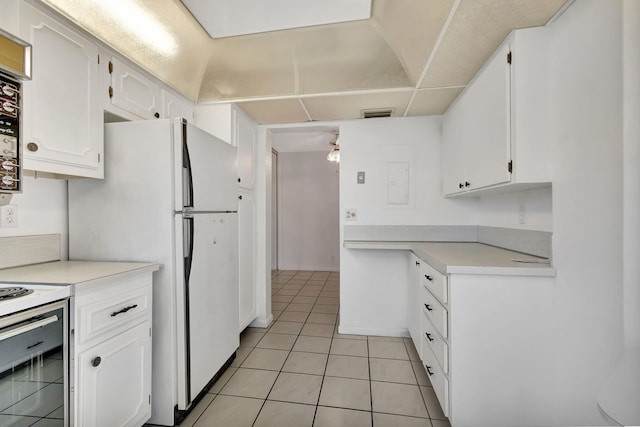 kitchen with white cabinetry, light tile patterned floors, and white appliances