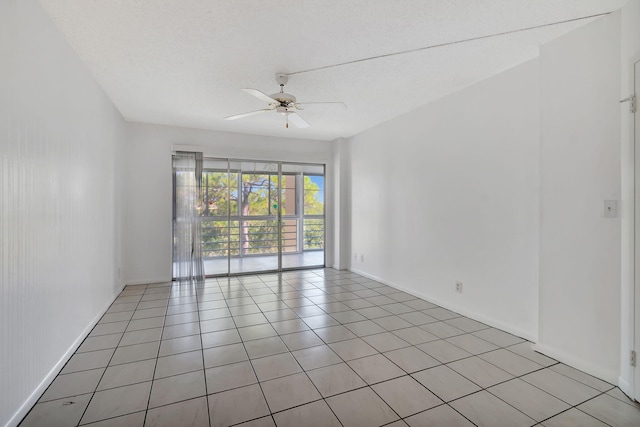 unfurnished room with ceiling fan, light tile patterned floors, and a textured ceiling