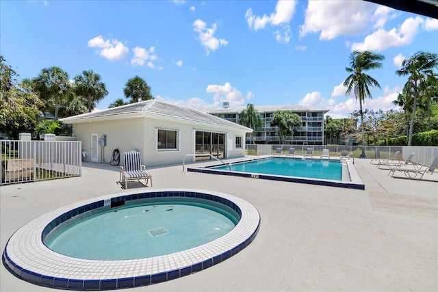 community pool with a patio area and fence