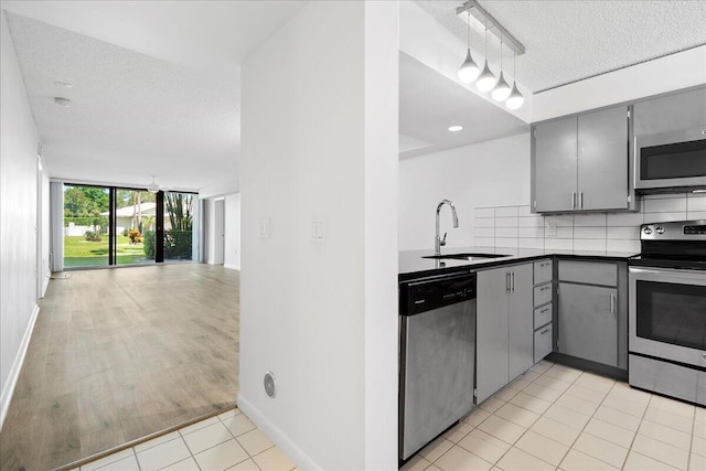 kitchen featuring gray cabinetry, sink, stainless steel appliances, and tasteful backsplash