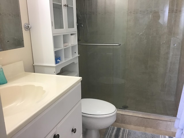 bathroom featuring vanity, toilet, and a shower with door