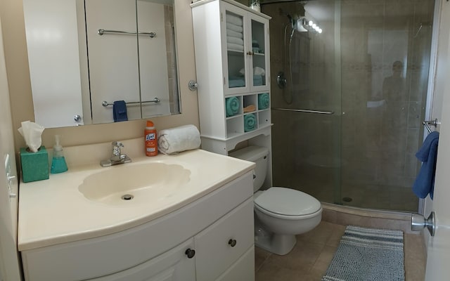 bathroom with tile patterned floors, vanity, toilet, and a shower with door