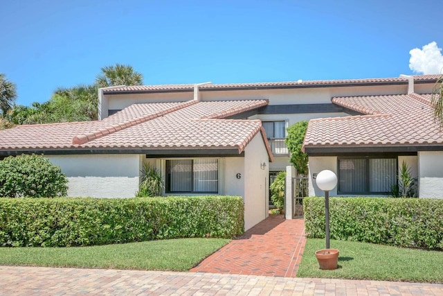 mediterranean / spanish home with a front lawn