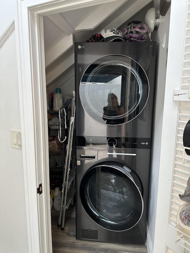 laundry room featuring wood-type flooring and stacked washer / drying machine