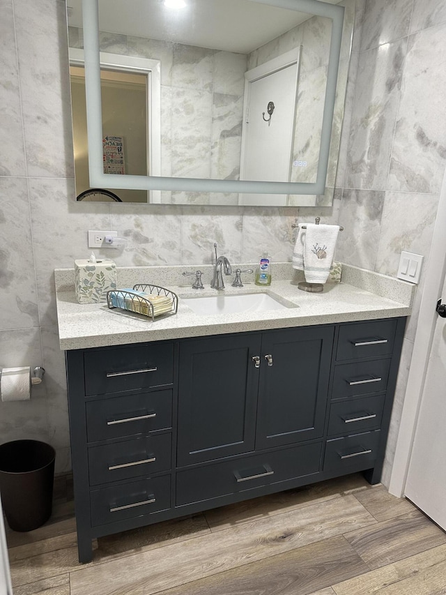 bathroom with vanity and tile walls