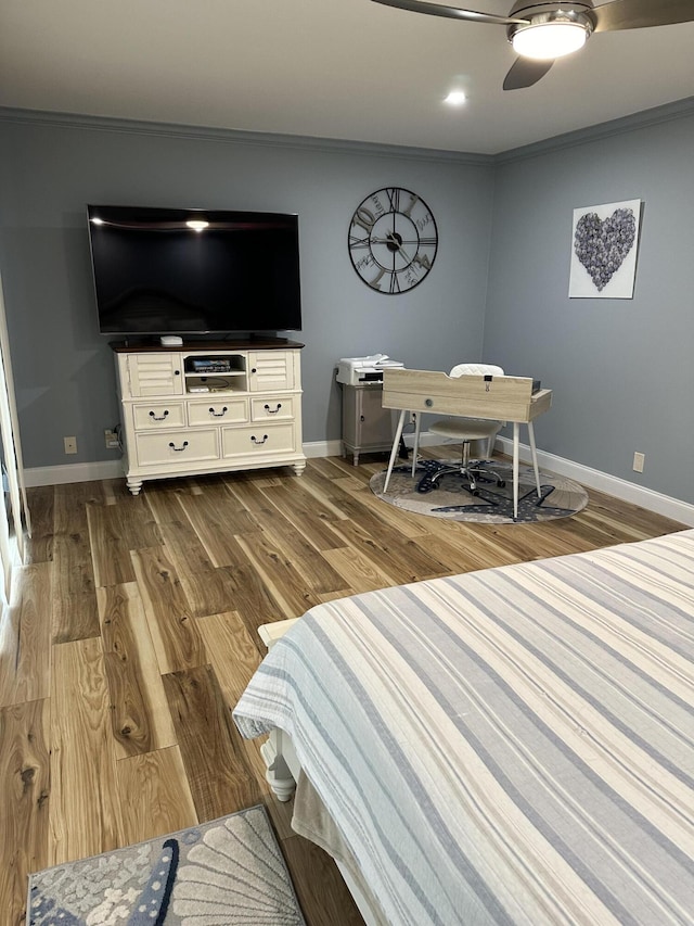 bedroom featuring hardwood / wood-style flooring, ceiling fan, and crown molding