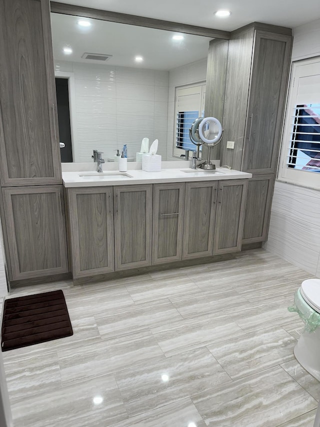 bathroom with vanity, toilet, and tile walls